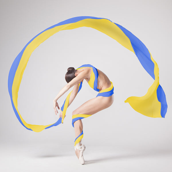Ballerina dancing en-pointe with a panglic of the Ukrainian flag - buy the photo as print and all the money will go to help the refugees in Ukraine